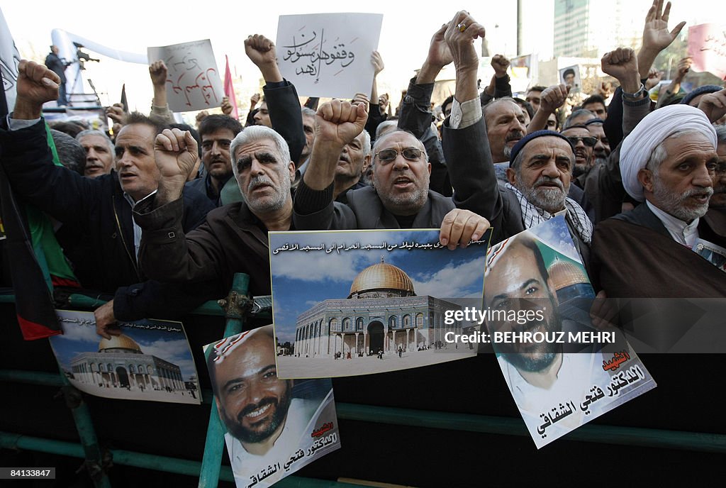 Iranian men shout slogans as they hold p