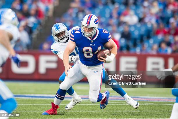 Nick O'Leary of the Buffalo Bills runs after the catch as he is pursued by Steve Longa of the Detroit Lions during the first quarter of a preseason...
