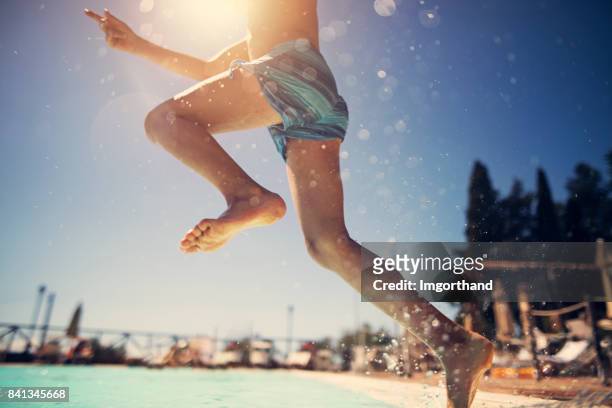 little boy jumping into swimming pool - swimming pool imagens e fotografias de stock