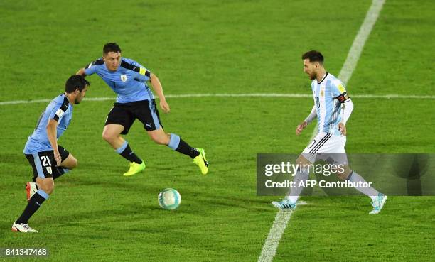 Uruguay's Alvaro Gonzalez and Cristian Rodriguez and Argentina's Lionel Messi eye the ball during their 2018 World Cup qualifier football match in...