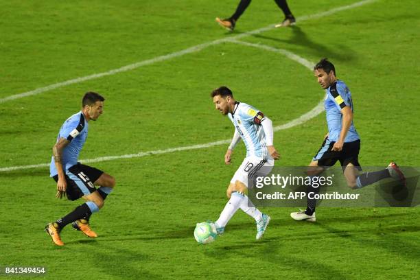 Argentina's Lionel Messi vies for the ball with Uruguay's Matias Vecino and Alvaro Gonzalez during their 2018 World Cup qualifier football match in...