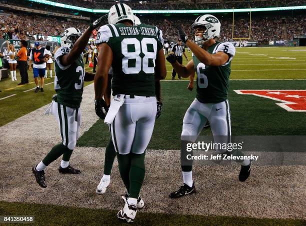 Austin Seferian-Jenkins of the New York Jets celebrates his touchdown with teammates Jeremy Clark and Chad Hansen of the New York Jets during their...