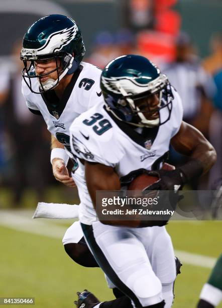 Matt McGloin hands off to Byron Marshall of the Philadelphia Eagles during their preseason game against the New York Jets at MetLife Stadium on...
