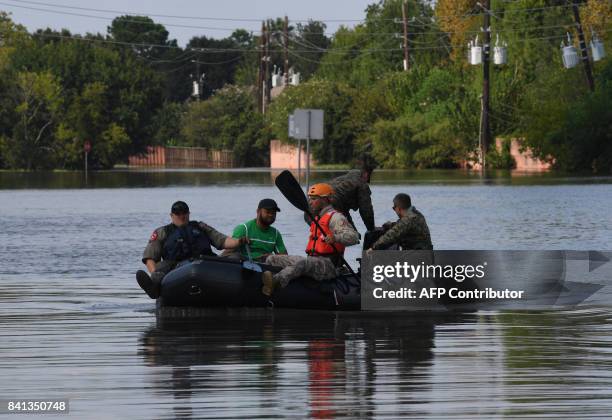 Military and State Troopers help evacuate a man beside the spillway area of the Barker Reservoir in the Coldine are a after Hurricane Harvey caused...