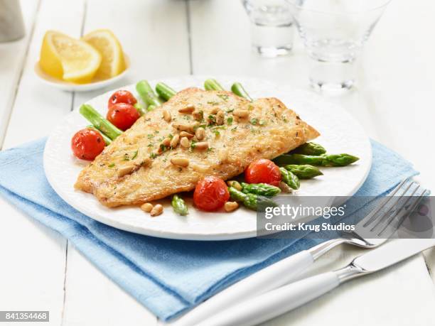 fish with asparagus and tomatoes - barramundi stock pictures, royalty-free photos & images