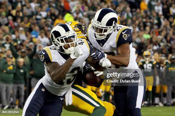 John Johnson and Isaiah Johnson of the Los Angeles Rams combine for a hit against Geronimo Allison of the Green Bay Packers in the second quarter...