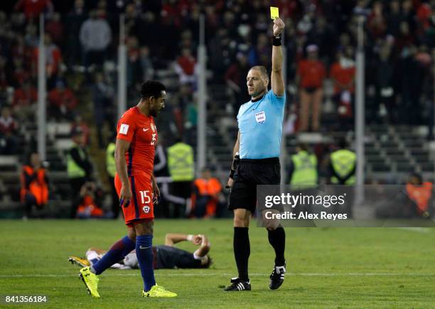 Referee Nestor Pitana shows a yellow card to Jean Beausejour of Chile during a match between Chile and Paraguay as part of FIFA 2018 World Cup...