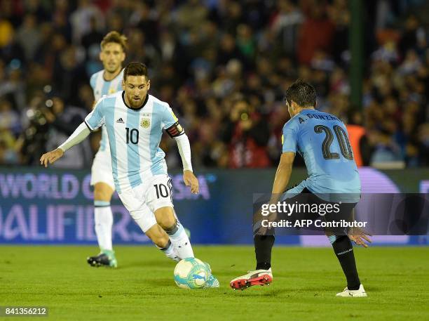Argentina's Lionel Messi and Uruguay's Alvaro Gonzalez vie for the ball during their 2018 World Cup qualifier football match in Montevideo, on August...