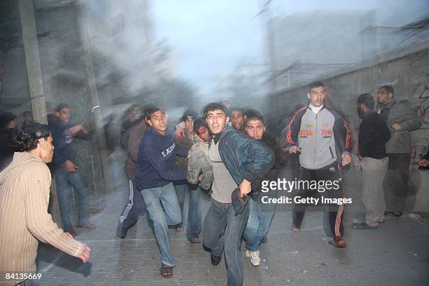 Wounded Palestinian man is carried away after an Israeli missile strike on the neighbouring home of a Hamas military leader on December 29, 2008 in...