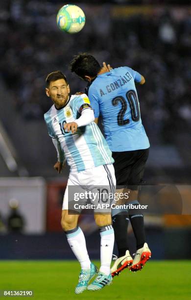 Argentina's Lionel Messi and Uruguay's Alvaro Gonzalez jump for the ball during their 2018 World Cup qualifier football match in Montevideo, on...