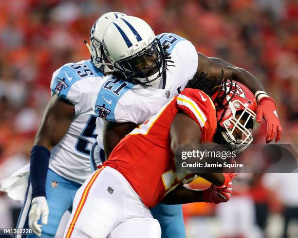 Running back Devine Redding of the Kansas City Chiefs carries the ball as strong safety Da'Norris Searcy of the Tennessee Titans defends during the...