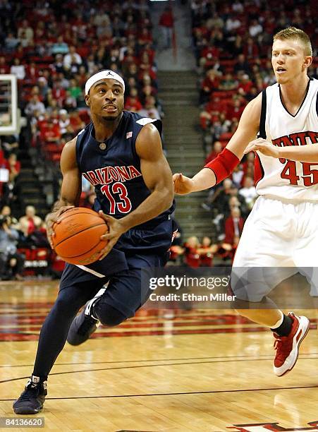 Nic Wise of the Arizona Wildcats drives against Joe Darger of the UNLV Rebels during the first half of their game at the Thomas & Mack Center...