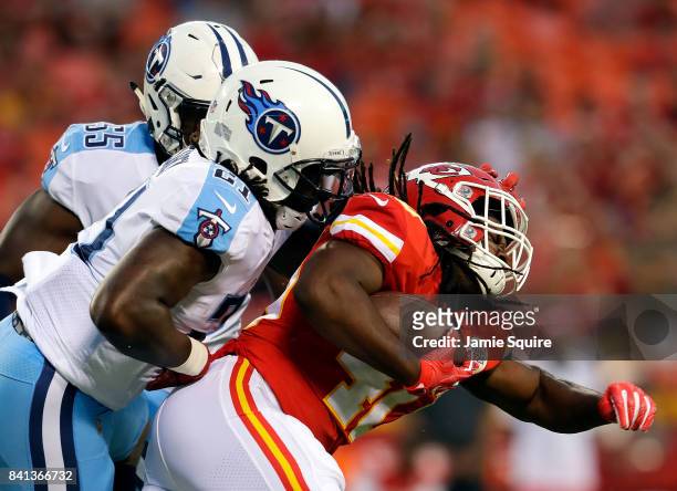Running back Devine Redding of the Kansas City Chiefs carries the ball as strong safety Da'Norris Searcy of the Tennessee Titans defends during the...