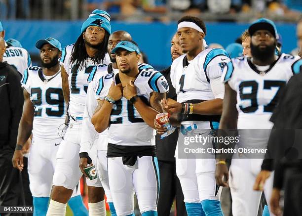 Carolina Panthers wide receiver Kelvin Benjamin , strong safety Kurt Coleman , quarterback Cam Newton watch the action on the field against the...