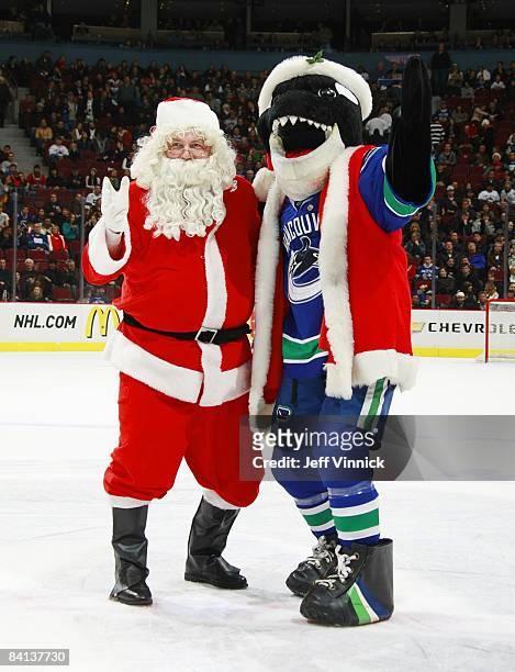 Vancouver Canucks mascot Fin and Santa Claus pose on the ice during the game between the Canucks and the Anaheim Ducks at General Motors Place on...