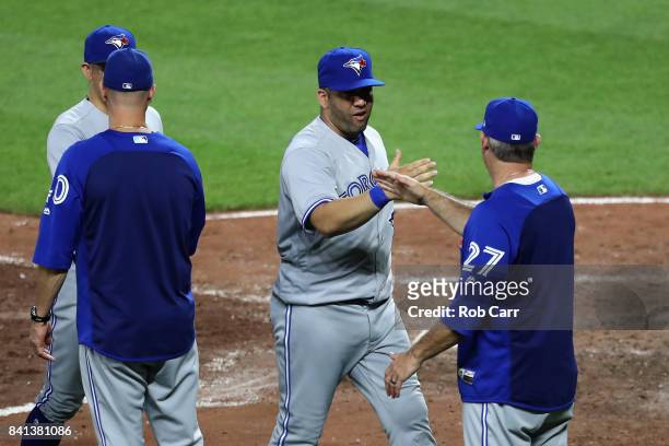 Kendrys Morales of the Toronto Blue Jays celebrates with Derek Shelton after the Blue Jays defeated the Baltimore OrioleBobby Dickerson of the...