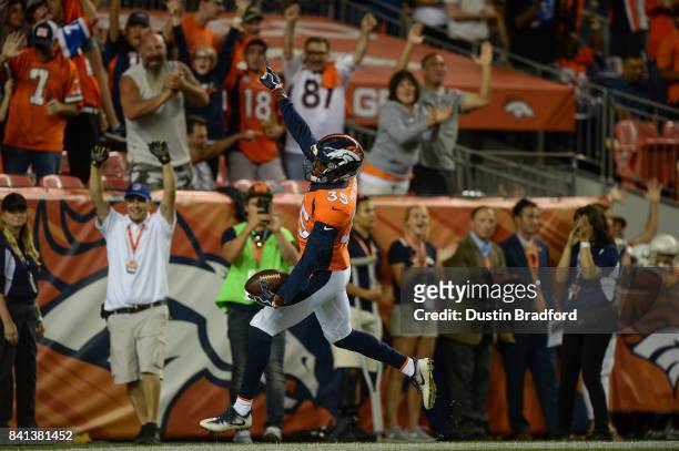 Defensive back Dymonte Thomas of the Denver Broncos celebrates in the end zone after intercepting a pass for a pick six touchdown in the second...