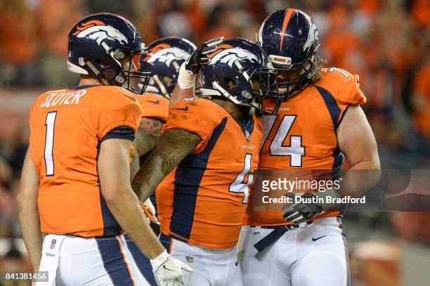 Running back Stevan Ridley of the Denver Broncos celebrates with Kyle Sloter and Ty Sambrailo after scoring a second quarter touchdown against the...