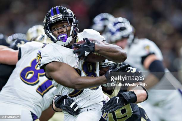 Bobby Rainey of the Baltimore Ravens is tackled by Adam Bighill of the New Orleans Saints during a preseason game at Mercedes-Benz Superdome on...