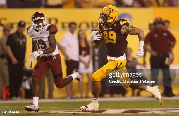 Wide receiver Jalen Harvey of the Arizona State Sun Devils runs with the football en route to scoring on a 53 yard touchdown reception past defensive...