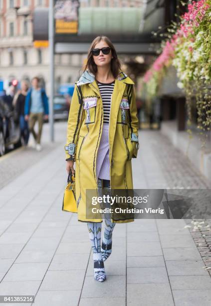 Darja Barannik wearing yellow Edda coat, bag and sock boots outside Jennifer Bloom on August 31, 2017 in Stockholm, Sweden.