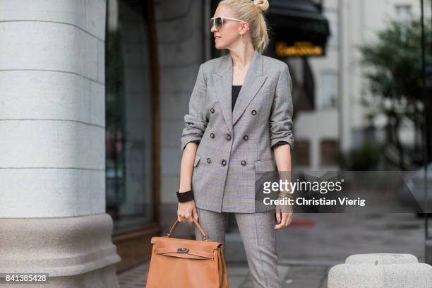 Guest wearing grey suit, brown Hermes bag outside Ida Sjoestedt on August 31, 2017 in Stockholm, Sweden.