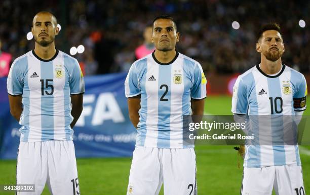Guido Pizarro, Gabriel Mercado and Lionel Messi of Argentina line up for the National Anthem prior to a match between Uruguay and Argentina as part...