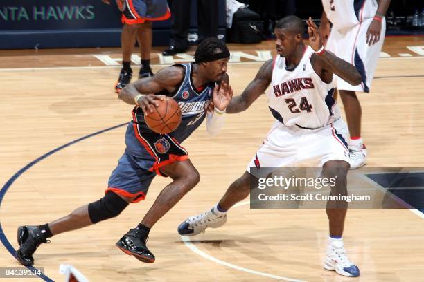 Gerald Wallace of the Charlotte Bobcats drives to the basket against Marvin Williams of the Atlanta Hawks during the game at Philips Arena on...