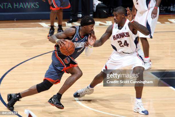 Gerald Wallace of the Charlotte Bobcats drives to the basket against Marvin Williams of the Atlanta Hawks during the game at Philips Arena on...