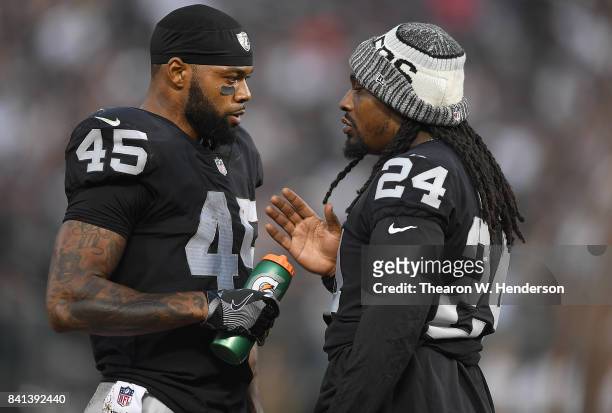Marshawn Lynch giving advice to running back George Atkinson of the Oakland Raiders during the first quarter against the Seattle Seahawks at...