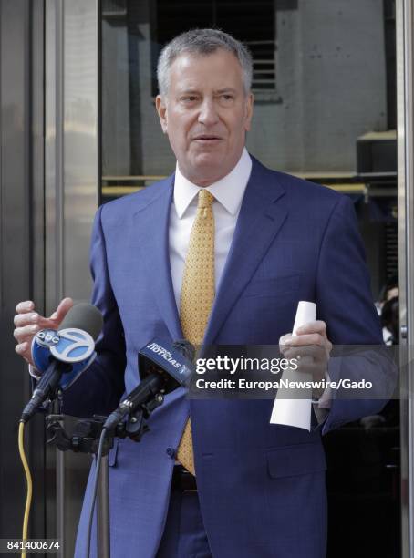 Three quarter length portrait of New York City mayor Bill de Blasio delivering a speech, with microphones visible, Greenwich Village, New York City,...