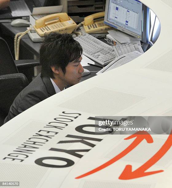 An employee of the Tokyo Stock Exchange monitors trading in Tokyo on December 30, 2008. Japanese share prices closed the year December 30 down 42.12...