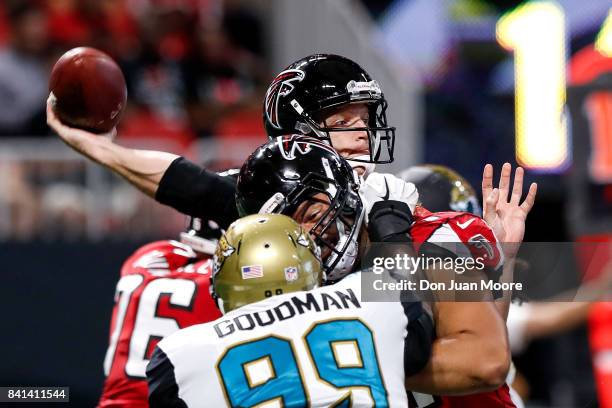 Quarterback Matt Simms of the Atlanta Falcons on a pass play over Defensive End Malliciah Goodman the Jacksonville Jaguars during a preseason game at...