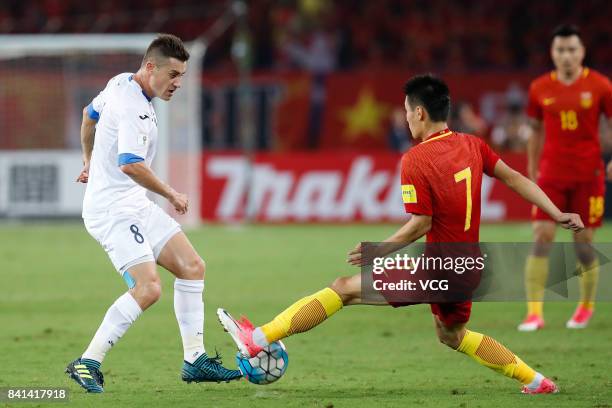 Wu Lei of China and Server Djeparov of Uzbekistan compete for the ball during the 2018 FIFA World Cup qualifier game between China and Uzbekistan at...