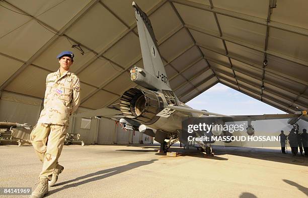 Dutch soldier walks past an F-16 fighter aircraft at Kandahar air field on December 29, 2008. More than 290 international soldiers serving in...