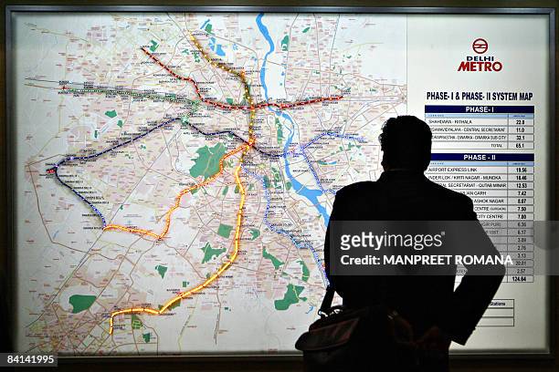 An Indian commuter takes a look at a Delhi Metro route map in New Delhi on December 30 during a media preview of the Metro Museum. The Metro Museum,...