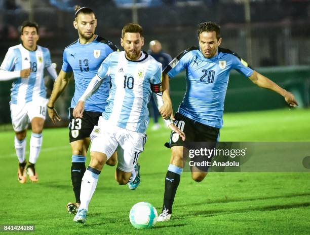 Lionel Messi of Argentina vies for the ball agains Gaston Silva and Alvaro Gonzalez of Uruguay during the 2018 FIFA World Cup qualifying match...