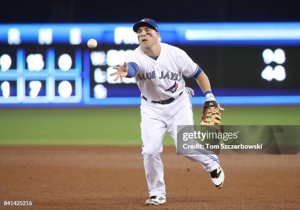 Steve Pearce of the Toronto Blue Jays makes the play and flips the ball to the pitcher covering first base to get the out in the sixth inning during...