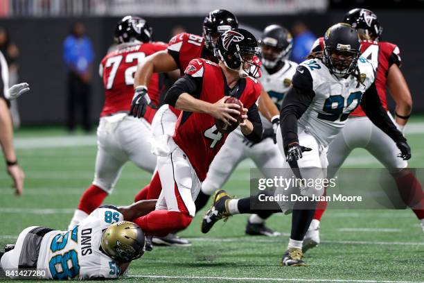 Quarterback Matt Simms of the Atlanta Falcons is tackled by Linebacker P.J. Davis of the Jacksonville Jaguars during a preseason game at...