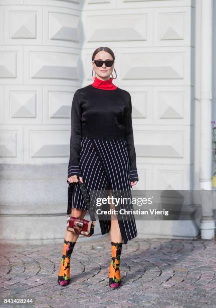 Lena Lademann wearing Balenciaga sock boots with floral print, black striped dress, knit, red turtleneck outside House of Dagmar on August 31, 2017...