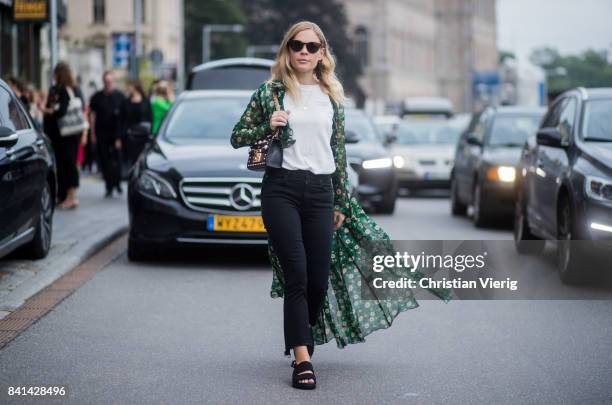 Jessie Bush wearing kimono, navy denim jeans, Gucci bag outside House of Dagmar on August 31, 2017 in Stockholm, Sweden.