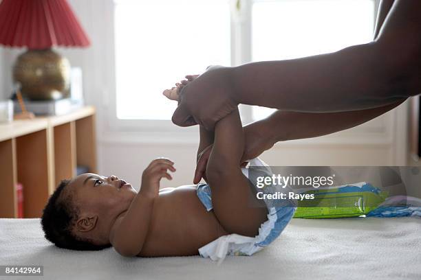 baby having his nappy changed - adult diaper stockfoto's en -beelden