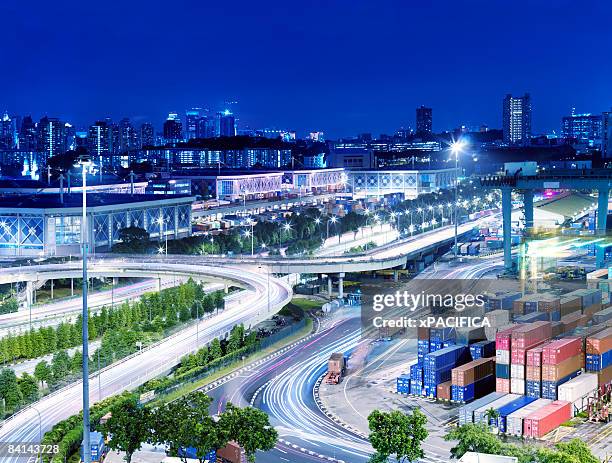 a busy container shipping terminal at night - generation x foto e immagini stock