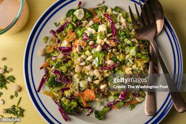 Crunchy Salad With Curry Lime Vinaigrette with utensils and dressing sauce on a yellow board shot on January 24th, 2017 in Washington DC.