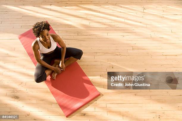 woman sitting on yoga mat. - holzboden von oben stock-fotos und bilder