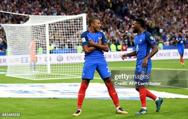 France's forward Kylian Mbappe celebrates with teammate forward Thomas Lemar after scoring a goal during the FIFA World Cup 2018 qualifying football...