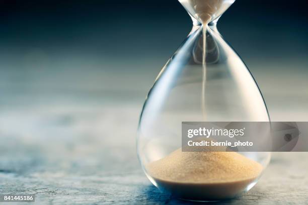 flujo de reloj de arena - sand fotografías e imágenes de stock