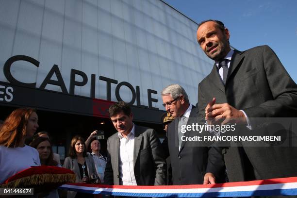 French Prime Minister Edouard Philippe prepares to cut the ribbon next to Chalons-en-Champagne mayor Benoist Apparu and Grand Est regional council...