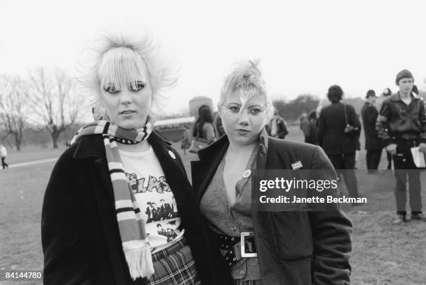 Punk girls in Hyde Park, London 1979. Both young women have outrageous, spiky hairstyles and have applied exaggerated eye make-up.