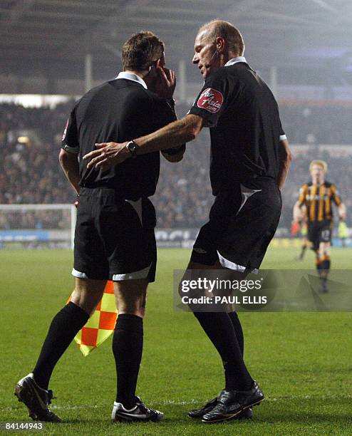 Referee Steve Bennett speaks his linesman on December 30, 2008 in Hull. Bennett awarded a penalty for a handball but changed his decision after...
